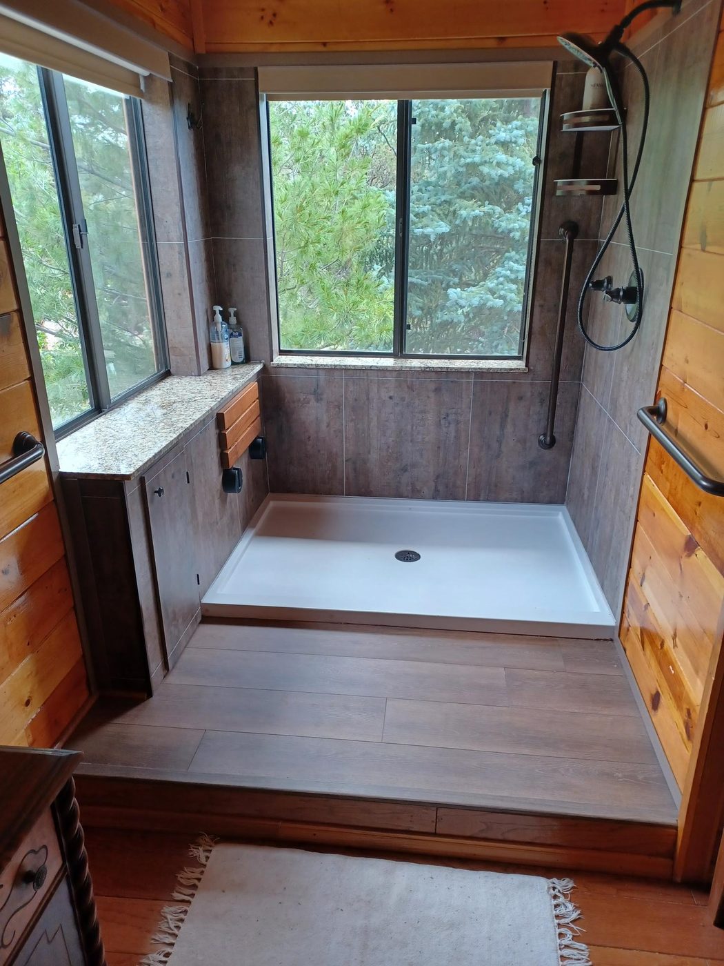 A walk-in shower with warm wood-look walls and an easy step-in